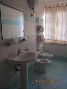 a bathroom with a sink and a toilet and a mirror at Albergo Little Garden in Formia