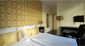 a bedroom with a white bed with a desk and a chair at Hotel Domspitzen in Cologne