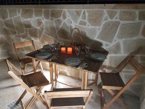 a wooden table with plates and candles on it with chairs at Vivenda da Eva in Arcos de Valdevez