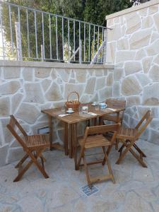 a wooden table and two chairs sitting next to a stone wall at Vivenda da Eva in Arcos de Valdevez