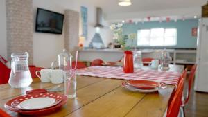 a wooden table with red and white plates on it at Llety'r Adar in Port Dinorwic