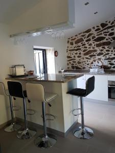 a kitchen with a counter and two bar stools at Vivenda da Eva in Arcos de Valdevez