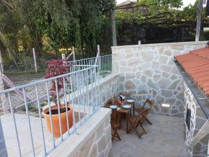 a patio with a table and a vase on a wall at Vivenda da Eva in Arcos de Valdevez +7 photos
