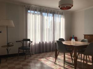 a dining room with a table and chairs and a large window at MAISON A LA CAMPAGNE PROCHE BAIE DE SOMME in Arrest