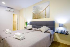 a bedroom with a large bed with two white towels on it at Armijorooms in Nerja