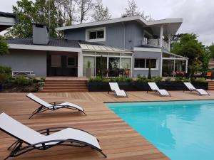 a house with a swimming pool and chairs next to a house at Villa Gayac in Gradignan