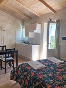 ラ・スペツィアにあるAgriturismo Mamma Chicaのベッド1台付きの部屋、テーブル付きのキッチンが備わる客室です。