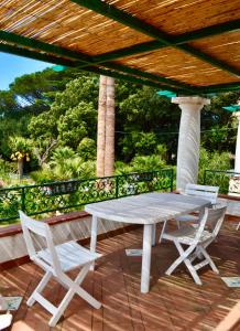 un tavolo bianco e sedie su una terrazza in legno di Casa Giovanna a Capri