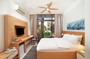a hotel room with a bed and a tv at The LifeCo Bodrum Well-Being Detox Center and Vegan Hotel in Golturkbuku