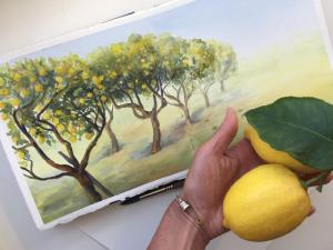 a person holding a lemon in front of a painting at Hotel Al Mulino in Anacapri