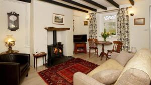 a living room with a couch and a fireplace at Ty Doli Cottage, rural location just outside Conwy town in Llangelynin +3 photos