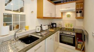 a kitchen with a sink and a counter top at Ty Doli Cottage, rural location just outside Conwy town in Llangelynin