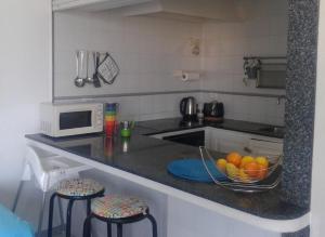 una cucina con bancone e cesto di frutta di Lovely flat with sea-view, 1 minute walk to beach a El Médano