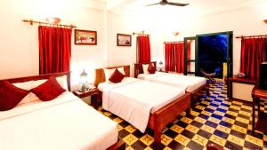 two beds in a room with red curtains at Villa Wat Damnak in Siem Reap +47 photos