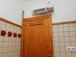 una puerta de madera en un baño con ventilador en Casa de Abajo, en Prado del Rey