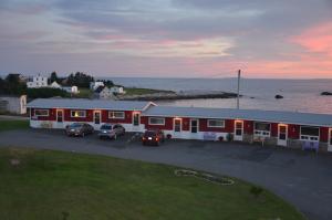 a building with cars parked in a parking lot at Clifty Cove Motel in Peggy's Cove