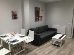 レオンにあるAPARTAMENTOS GyC VIVIENDAS DELUXEの黒いソファとテーブルのあるリビングルーム