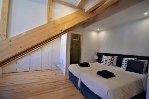 two beds in a room with a wooden ceiling at Silver Side River in Lisbon