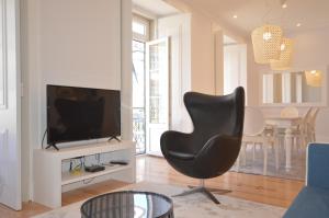 a living room with a black chair and a television at Silver Side River in Lisbon