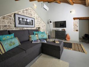 - un salon avec un canapé et un mur en pierre dans l'établissement Boutique Holiday Home in Vodnjan with Roof terrace, à Vodnjan