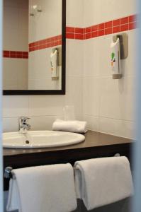 a bathroom with a sink and a mirror and towels at ibis Styles Segre in Segré