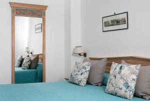 a bedroom with a blue bed and a mirror at Hotel Al Mulino in Anacapri