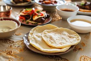 a table with plates of food and bowls of soup at Varenya Agro Resort in Kolvan