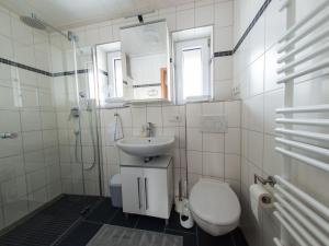 La salle de bains blanche est pourvue d'un lavabo et de toilettes. dans l'établissement Cosy holiday home with sauna in the Allg u, à Burggen