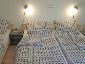 - une chambre avec 2 lits avec des draps bleus et blancs dans l'établissement Cosy holiday home with sauna in the Allg u, à Burggen