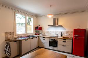 a kitchen with a red refrigerator and a window at Le Garage, Le Gite in Fontevraud-l'Abbaye