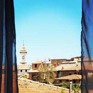 widok na miasto z wieżą zegarową w obiekcie Palazzetto del Pittore w mieście San Quirico dʼOrcia