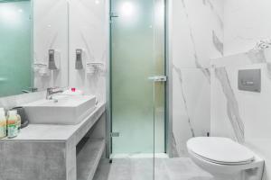 La salle de bains est pourvue de toilettes, d'un lavabo et d'une douche. dans l'établissement Anna Hotel, à Pefkohori