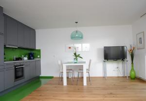 a kitchen with a table and chairs and a tv at Seeappartement Marina in Pörtschach am Wörthersee