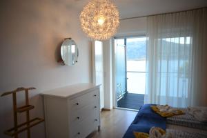 a bedroom with a chandelier and a room with a bed and a window at Seeappartement Marina in Pörtschach am Wörthersee