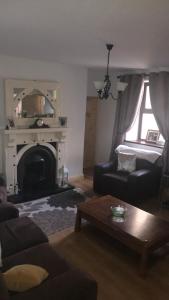 a living room with a couch and a fireplace at The West House in Belmullet