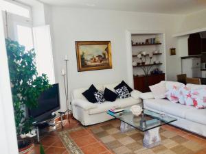un soggiorno con divano bianco e TV di Villa Alessandro - Anacapri ad Anacapri