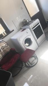 uma máquina de lavar roupa e uma cadeira num quarto em The West House em Belmullet