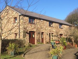 a stone house with a driveway in front of it at King's Head Inn in Llangennith