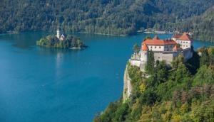 a castle on an island in the middle of a lake at Studio Jan in Zgornje Gorje