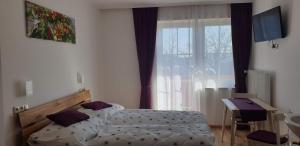 Schlafzimmer mit einem Bett, einem Schreibtisch und einem Fenster in der Unterkunft Huberhof im Almenland in Sankt Kathrein am Offenegg