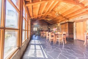 uma sala de jantar com mesa, cadeiras e janelas em Casa Lourán em Monfero