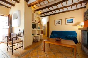 salon z niebieską kanapą i stołem w obiekcie Casa de la Luz w mieście Bubión