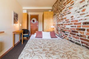a hotel room with a brick wall and a bed at Lossiranta Lodge in Savonlinna