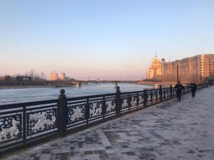 two people walking on a bridge over a body of water at Гостиница "Алтын Орда" in Astana