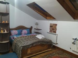a bedroom with a bed with a wooden headboard at Квартира-студія Шале in Truskavets