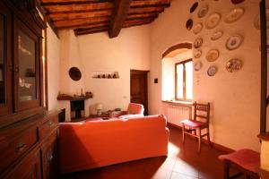 un soggiorno con divano arancione e tavolo di Terrazza e Vista Mare a Castagneto Carducci