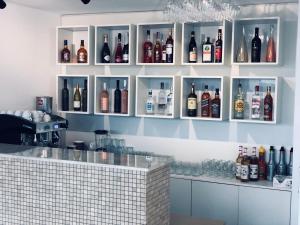 um bar com garrafas de álcool na parede em Hotel Clas Mamaia Nord em Mamaia Nord – Năvodari