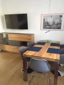 a dining room with a table and a flat screen tv at 3-Zimmer Ferienwohnung Bahnhofsnähe in Fulda +24 photos