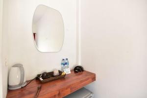 a bathroom with a mirror and a wooden shelf at The Reef Resort in Koh Kradan