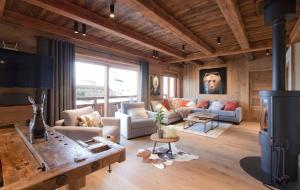 a living room with couches and a tv at Odalys Chalet Le Lys in Les Deux Alpes